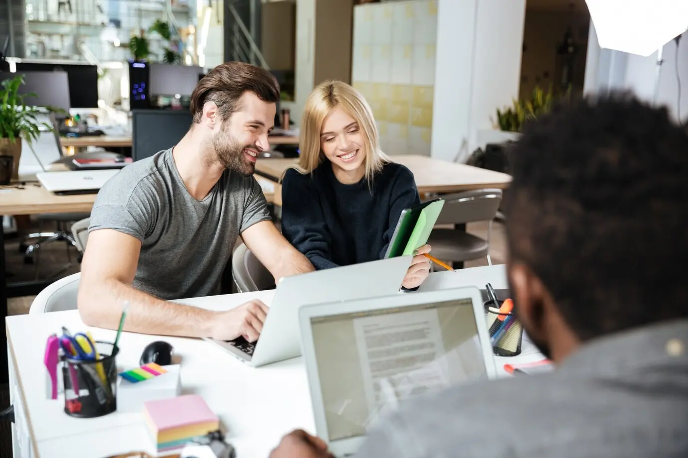 Happy young colleagues sitting in a coworking office