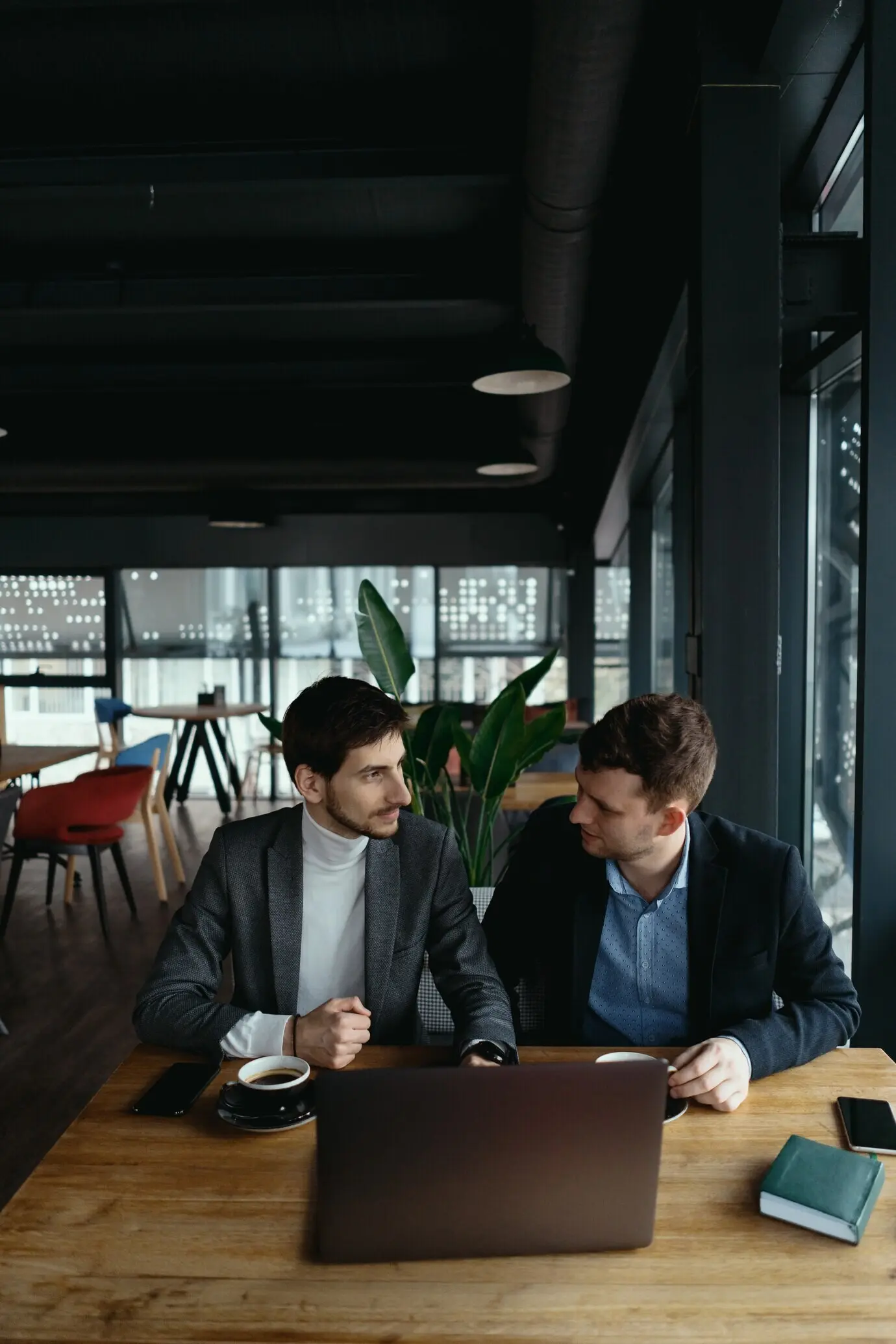 Two young businessmen are having a successful meeting at a restaurant.